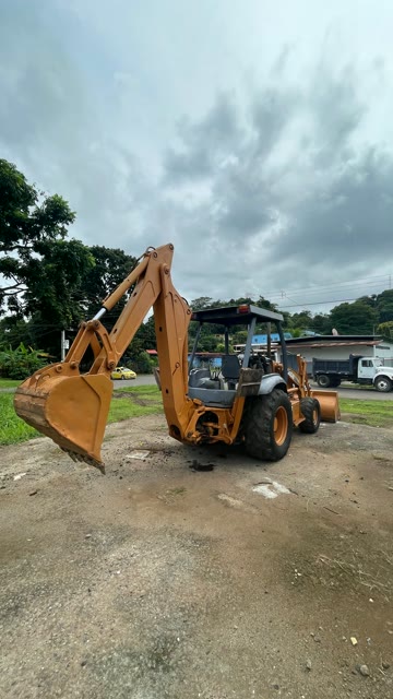 CASE 580M, vista trasera con brazo retro elevado